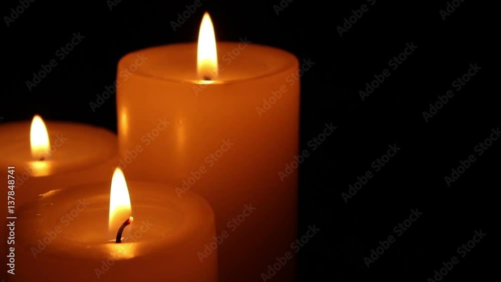 Closeup of candles burning at night on black background. Closeup of candles burning at night on black background.