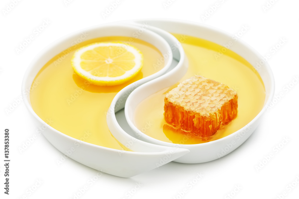 Honey, a honeycomb and a slice of lemon in two yin yang trays, isolated on white Honey, a honeycomb and a slice of lemon in two yin yang trays, isolated on white