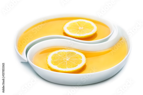 Honey and two slices of lemon in two yin yang trays, isolated on white