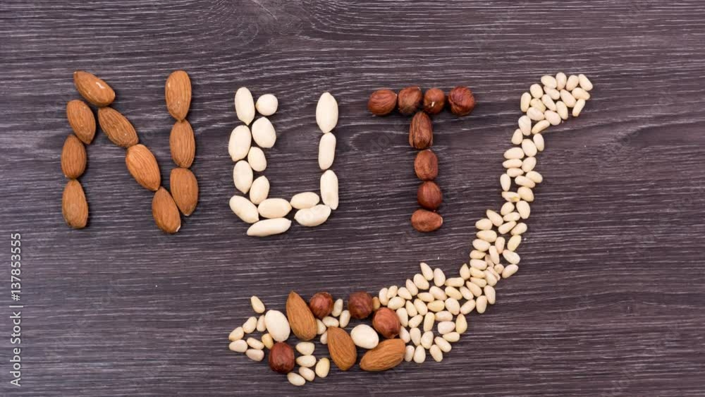 The letters forming from a pile of nuts. Nuts moving into a word NUTS. Stop motion The letters forming from a pile of nuts. Nuts moving into a word NUTS. Stop motion