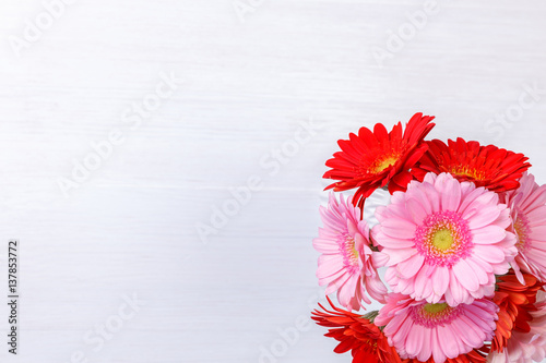 Gerbera flowers in vase on white wood vintage background. 8 march or Valentines day love design. Fresh natural flowers. Painted wooden planks.