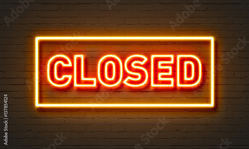 Closed neon sign on brick wall background. photo