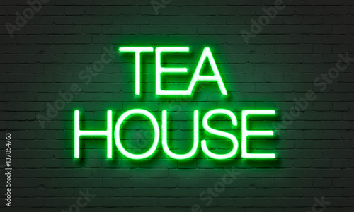 Tea house neon sign on brick wall background.