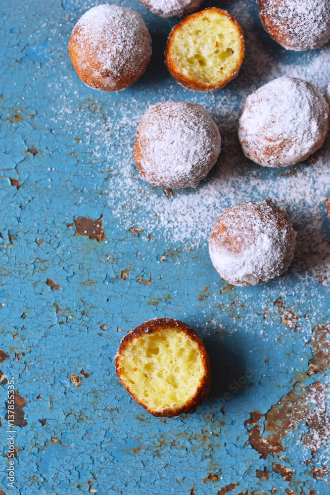 Homemade donuts with powdered sugar on a blue, old background Homemade donuts with powdered sugar on a blue, old background