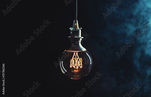 Leinwand Poster Vintage lightbulb on dark background