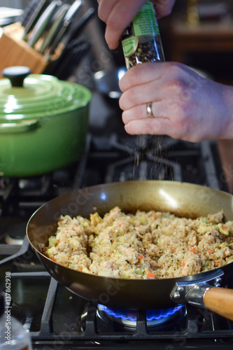 Wallpaper Mural man grinds pepper on fried rice in wok over gas flame stove Torontodigital.ca