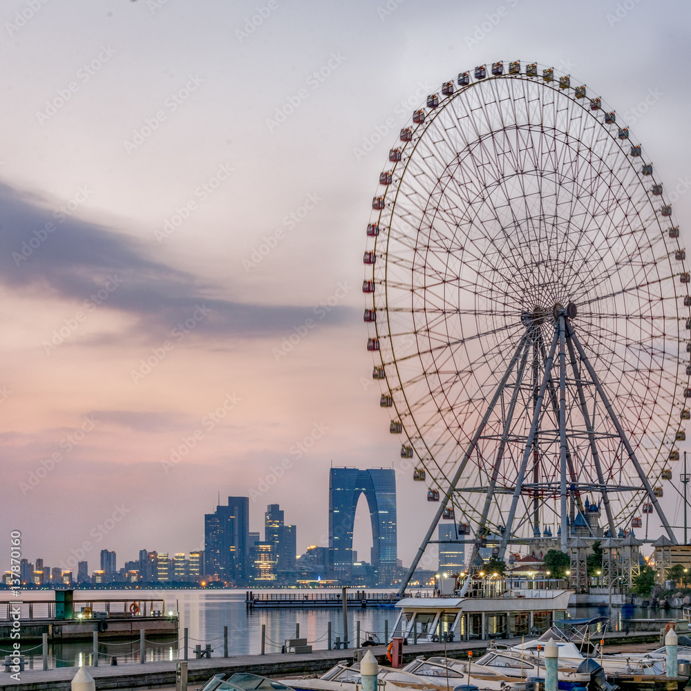 Naklejka premium ferris wheel with cityscape in background in Suzhou,China.