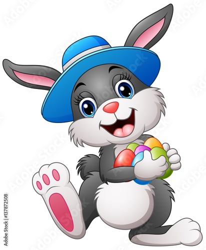 Happy easter bunny wearing a hat carrying eggs