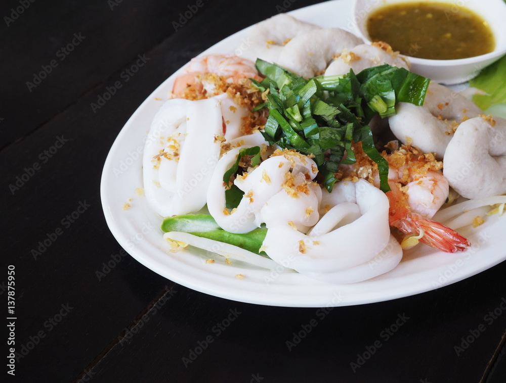 Boiled seafood dip with hot and sour sauce on white plate Boiled seafood dip with hot and sour sauce on white plate