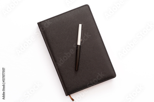 black diary and pen up on a white background