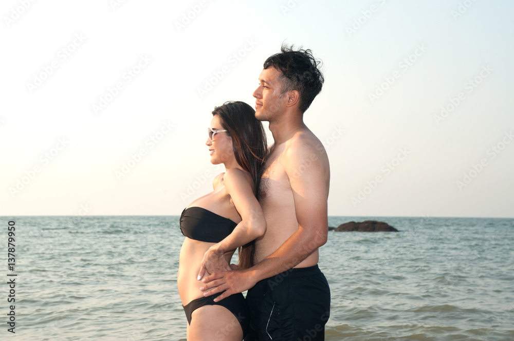 Fototapeta premium Lovely young adult couple standing on the beach .