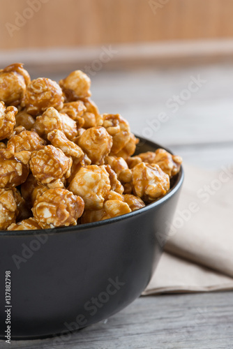 Caramel popcorn on wooden background