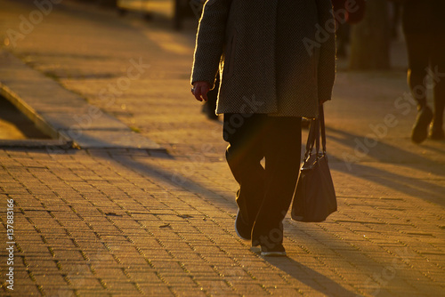 A woman walking on the pavement.
