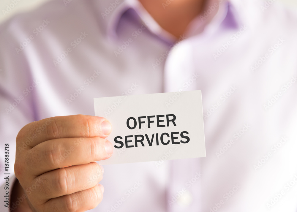 Businessman holding a card with text OFFER SERVICES Businessman holding a card with text OFFER SERVICES