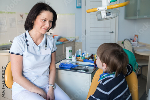 happy female dentist with talking to child