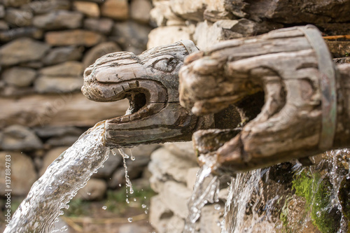 Wooden wall fountain in nepalese village in Annapurna Region, Nepal. photo