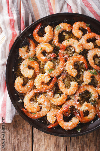 flavorful food: shrimp in garlic sauce with parmesan cheese and herbs closeup. vertical top view