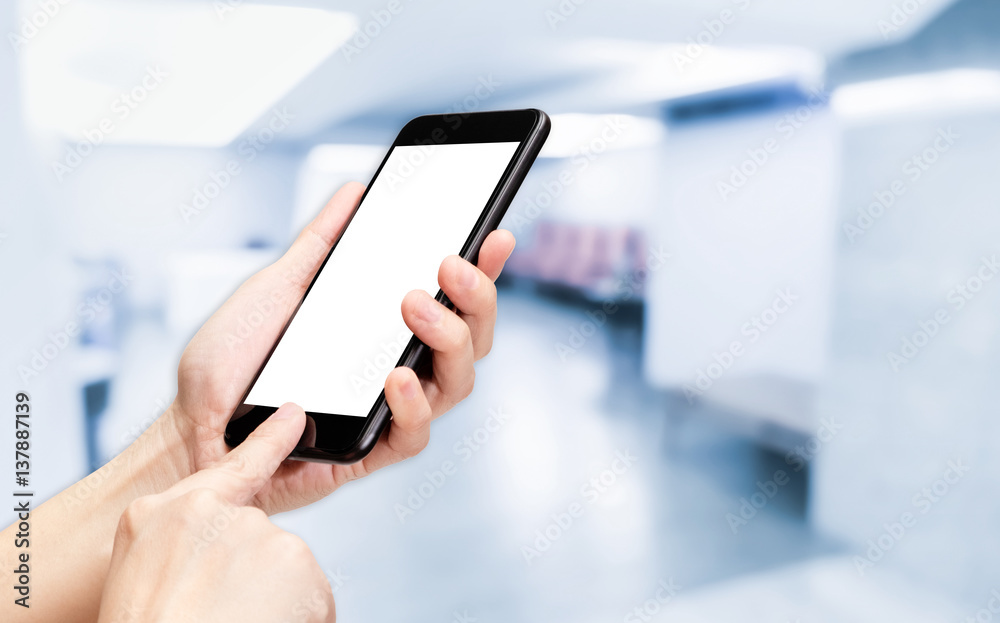 Hand click mobile phone with blur seminar hall room background bokeh light,White screen mock up template for adding your design or your text Hand click mobile phone with blur seminar hall room background bokeh light,White screen mock up template for adding your design or your text