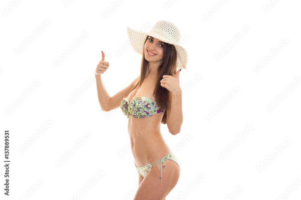 a young girl in a bathing suit and hat worth turning sideways and shows the class