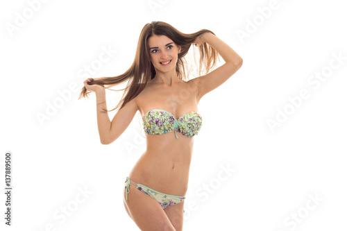 smiling young girl in bathing suit holding hands hair