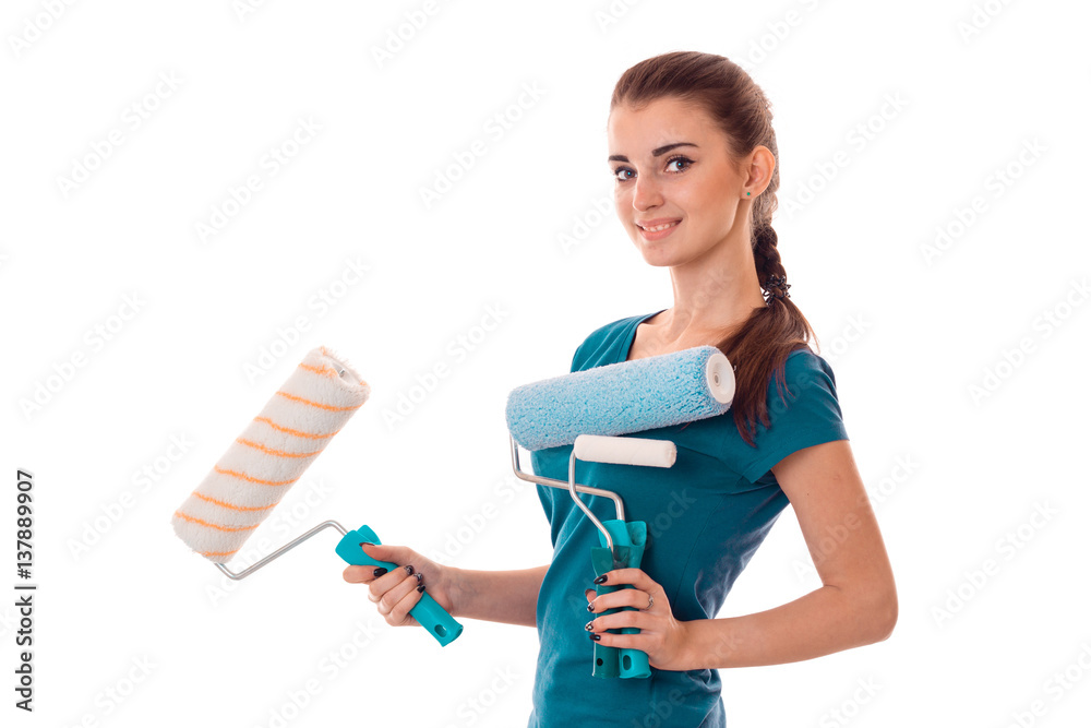 a young girl stands sideways and holding rollers for painting walls isolated on white background a young girl stands sideways and holding rollers for painting walls isolated on white background