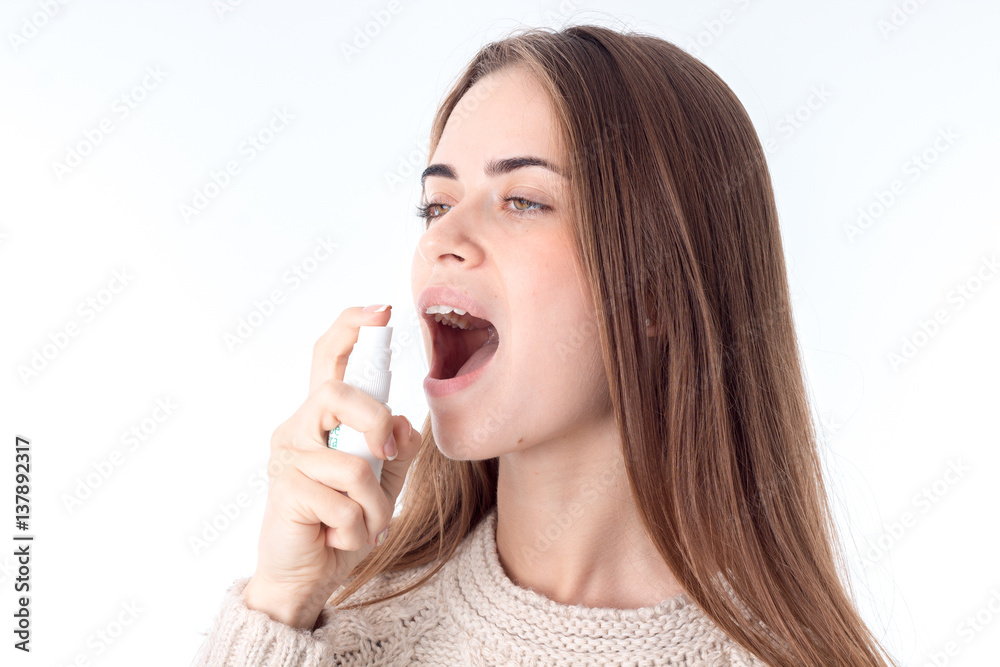 young girl holding a spray for the throat and squirting closeup young girl holding a spray for the throat and squirting closeup