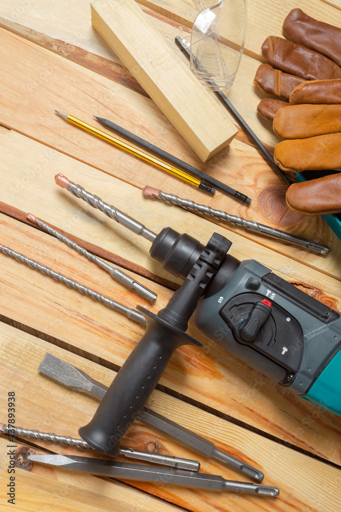 Electric hammer drill lies on a wooden table Electric hammer drill lies on a wooden table