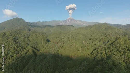 Aerial shot of Reventador Volcano erupting. Looking over the rainforest covered slopes and into the caldera where the cone is erupting a plume of ash. In the Ecuadorian Amazon.