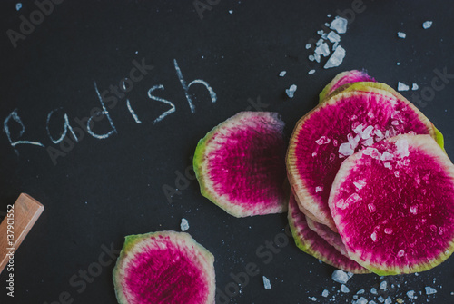 Watermelon Radishes Sliced, Sprinkled with Sea Salt on a black background
