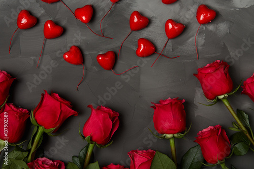 Composition of red roses on dark grey background. Romantic shabby chic decor. Top view. Love Concept. Valentines day Card with red hearts on black background with copyspace for greeting text