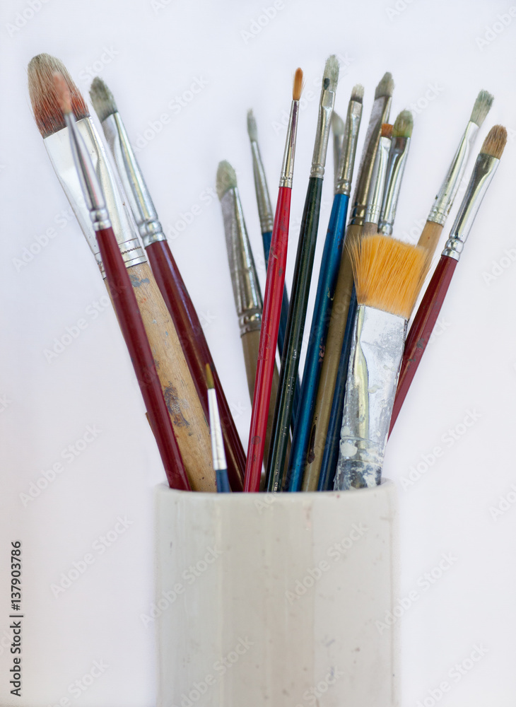 Collection of artist brushes in pottery vase