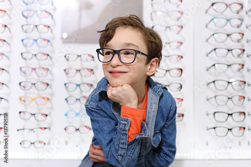 Fototapeta Naklejka Na Ścianę i Meble -  boy in glasses , at optics store

