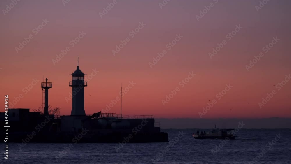 Fishing boats at sunrise swim near the lighthouse. Fishing boats at sunrise swim near the lighthouse.
