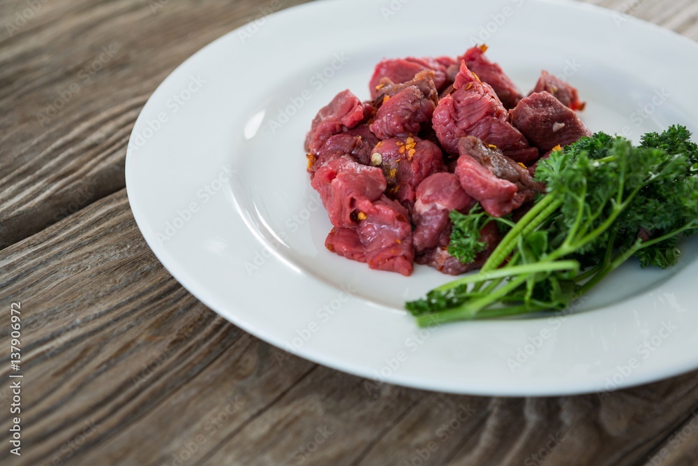 Diced beef and corainder leaves in white plate Diced beef and corainder leaves in white plate