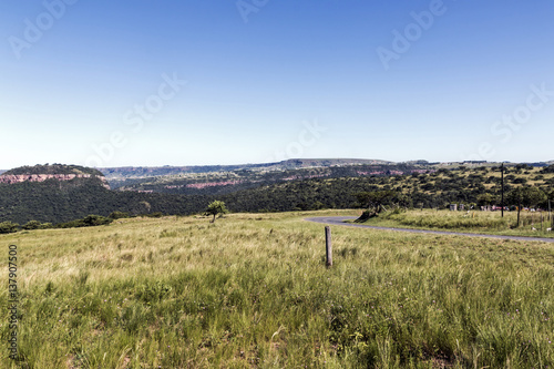  Grassland Against Distand Hills and Blue Sky Landscape