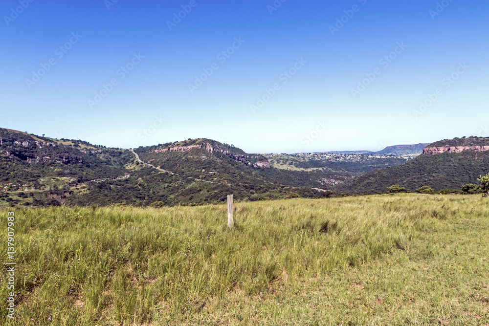  Grassland Against Distand Hills and Blue Sky Landscape