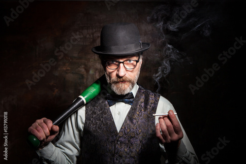 A bearded man in a bowler hat with a baseball bat