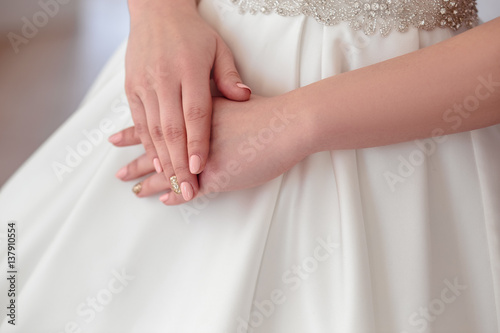 close-up portrait of beautiful brunette bride with elegant hairstyle and makeup, details of wedding dress