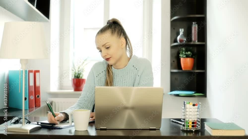 Absorbed woman working in her office and writing something, steadycam shot
Absorbed woman working in her office and writing something, steadycam shot