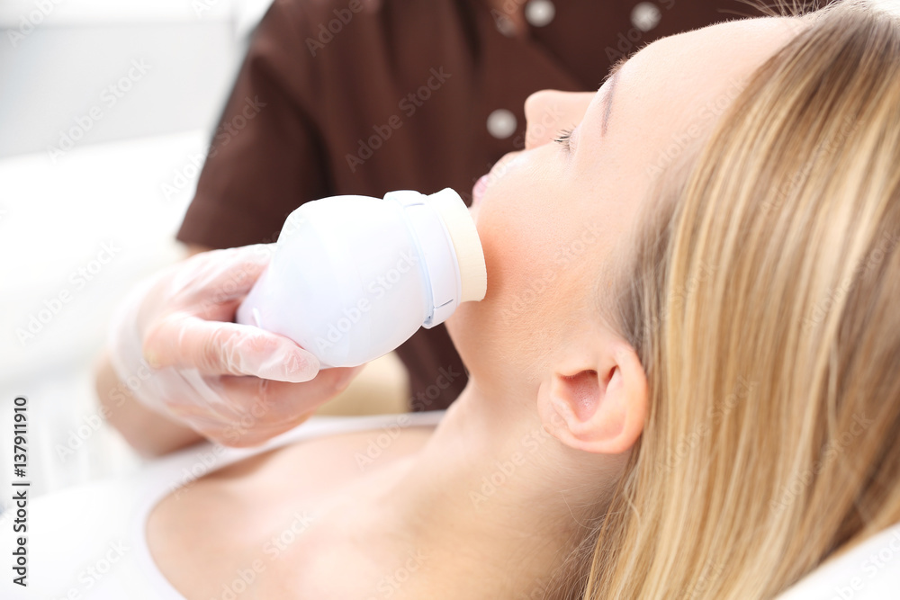 Peeling. Kosmetyczka w salonie kosmetycznym przykłada głowicę do twarzy kobiety. Peeling. Kosmetyczka w salonie kosmetycznym przykłada głowicę do twarzy kobiety.