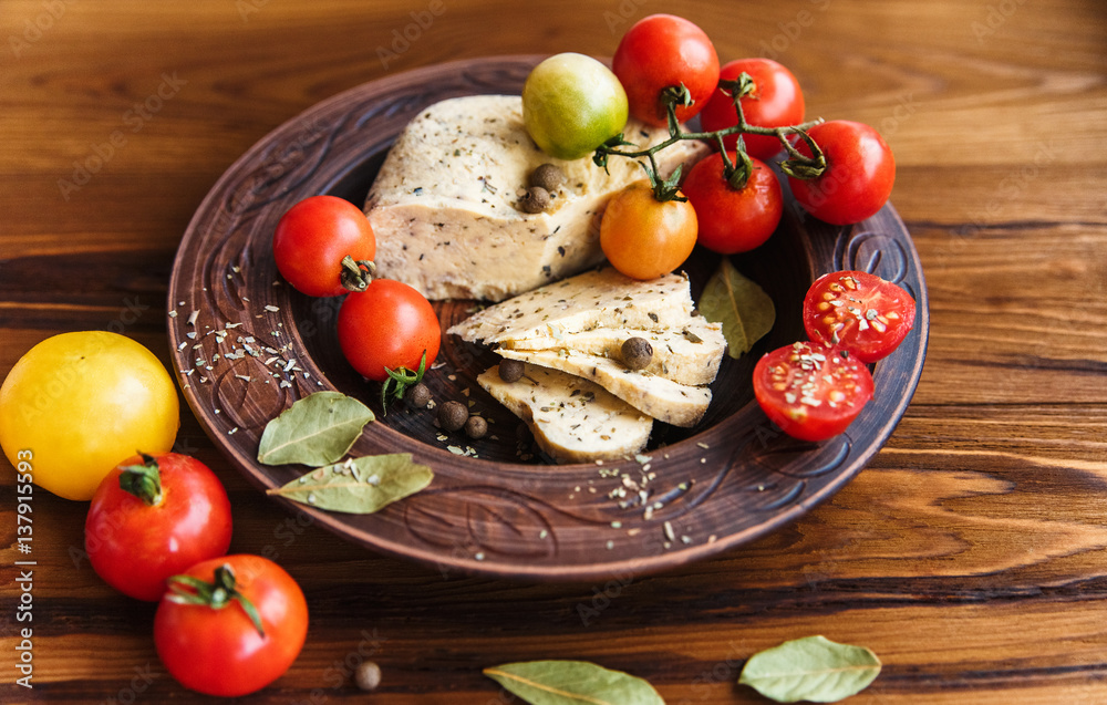homemade cheese,tomatoes with herb spice in rural pottery.wooden background homemade cheese,tomatoes with herb spice in rural pottery.wooden background