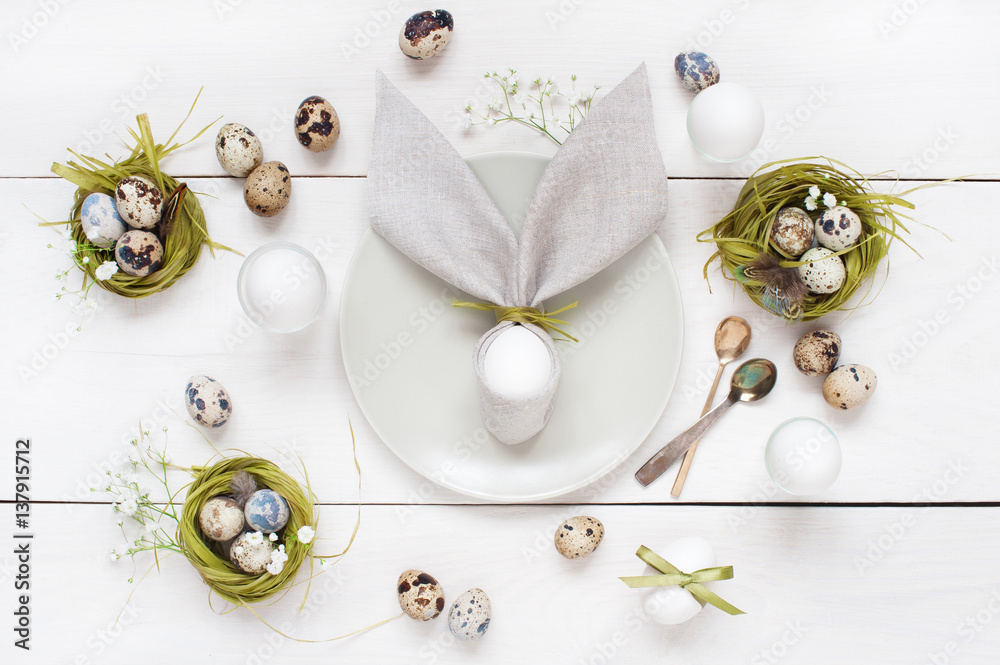 Easter table decoration with napkin in the form of rabbit ears, eggs and nests Easter table decoration with napkin in the form of rabbit ears, eggs and nests