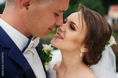 Close up portrait of charming wedding couple hugging on pier of the dock.