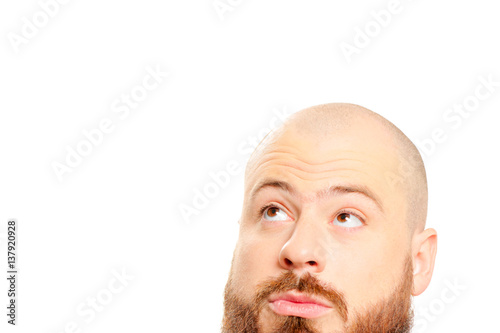 interested young bearded man looking up