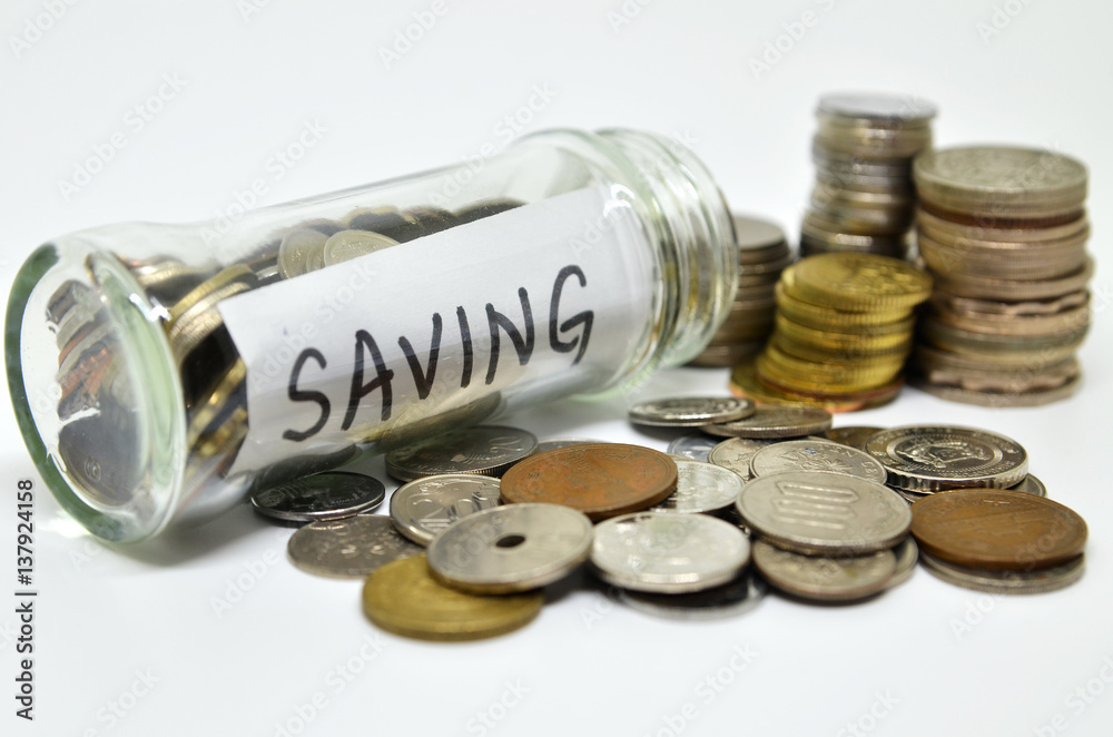 Saving lable in a glass jar with coins spilling out Saving lable in a glass jar with coins spilling out
