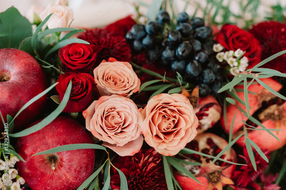 Fototapeta premium Autumnal wedding bouquet of roses, apples, grape and pomergranate