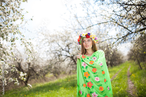 Portrait of beautiful natural woman in nice green dress in the garden of apple