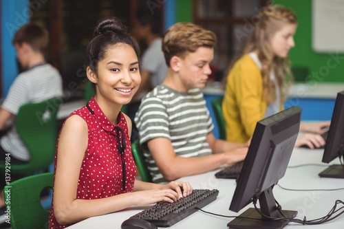 Smiling students studying in computer classroom