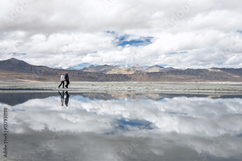 Two travelers walks near Tso Kar Lake in Himalaya Mountain