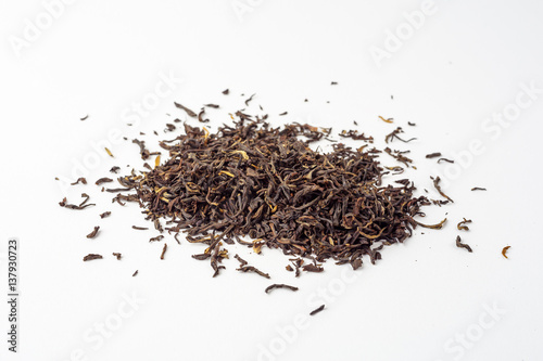 Dried black Chinese tea leaves on white background